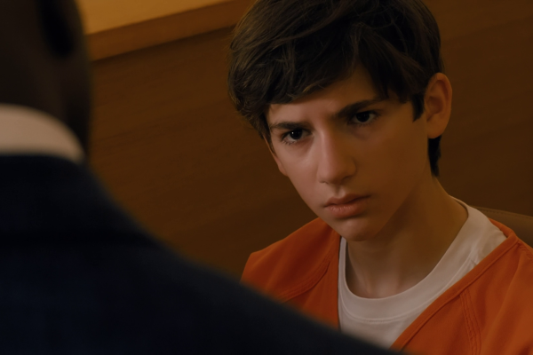 Daniel, in an orange jail jumpsuit, stares across the table at his lawyer during questioning in Cupertino.