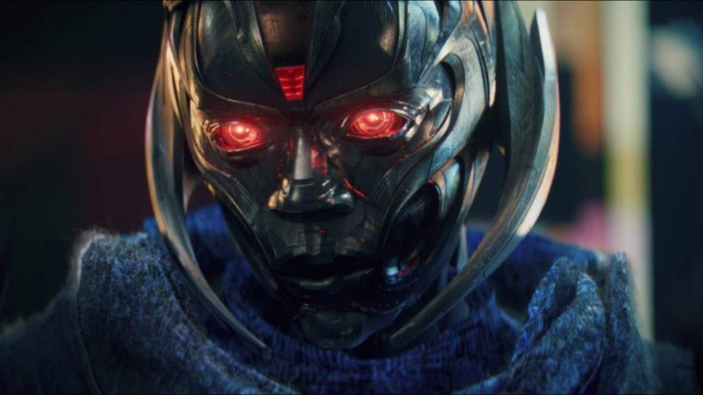 Jocasta, the Butcherbird, stares into the camera with glowing red eyes behind a silver metal mask in VisionQuest